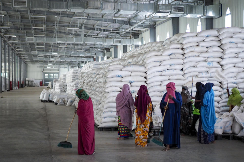 FILE - Workers clean the floor as sacks of food earmarked for the Tigray and Afar regions sits in piles in a warehouse of the World Food Programme (WFP) in Semera, the regional capital for the Afar region, in Ethiopia on Feb. 21, 2022. The aid agency Oxfam International warned Tuesday, March 22, 2022 that widespread hunger across East Africa could become "a catastrophe" without an injection of funds to the region's most vulnerable communities. (AP Photo, File)