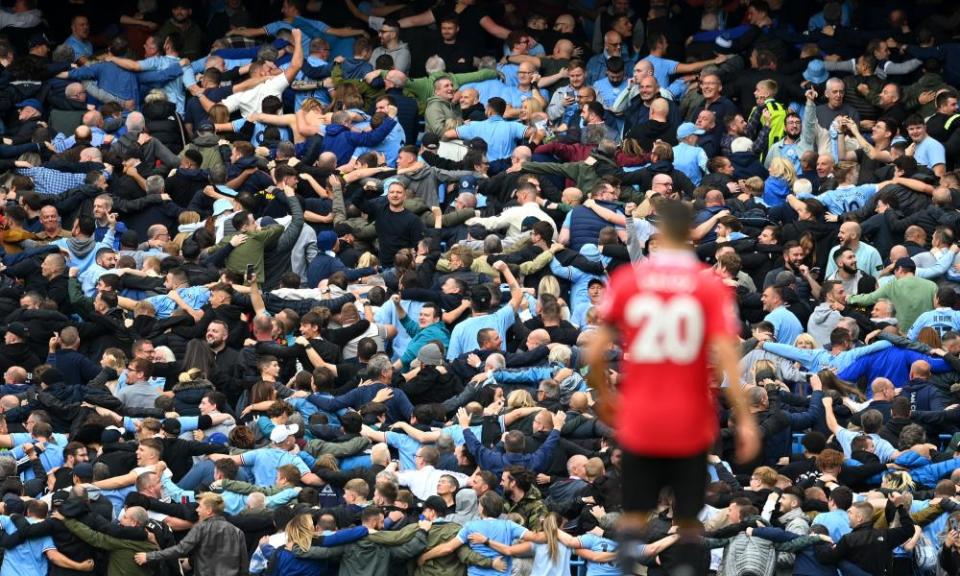 Manchester City fans celebrate after Erling Haaland scores against Manchester United