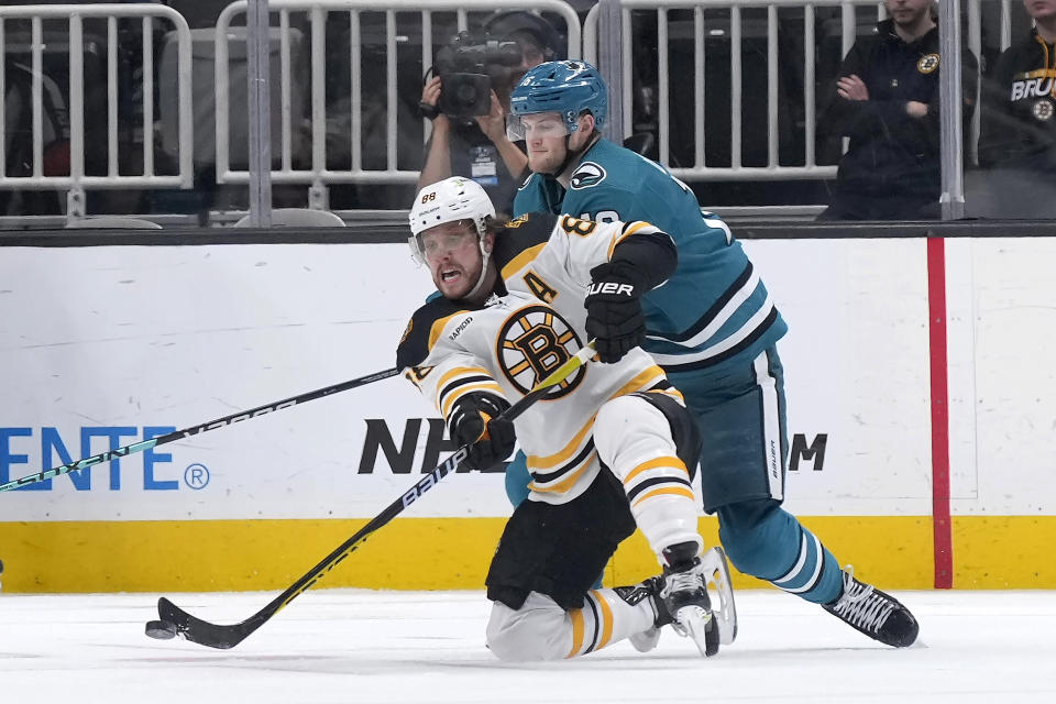 Boston Bruins right wing David Pastrnak (88) moves the puck up the ice as San Jose Sharks center Steven Lorentz (16) defends during the second period of an NHL hockey game, Saturday, Jan. 7, 2023, in San Jose, Calif. (AP Photo/Tony Avelar)