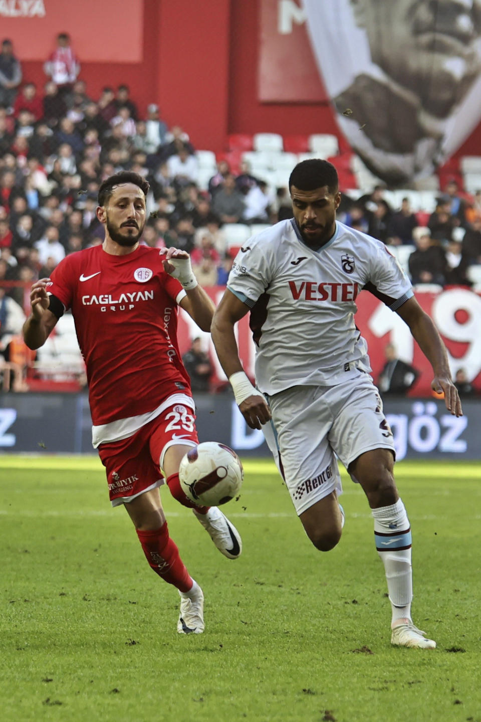 Antalyaspor's Sagiv Jehezkel, left, vies for the ball with Trabzonspor's Rayyan Baniya during a Turkish Super Lig soccer match between Antalyaspor and Trabzonspor in Antalya, southern Turkey, Sunday, Jan. 14, 2024. Turkish authorities have detained Turkish top-flight soccer club Antalyaspor's Israeli player Sagiv Jehezkel for questioning after he displayed solidarity with people held hostage by the Hamas militant organization during a league game. (Cafer Eser/IHA via AP)