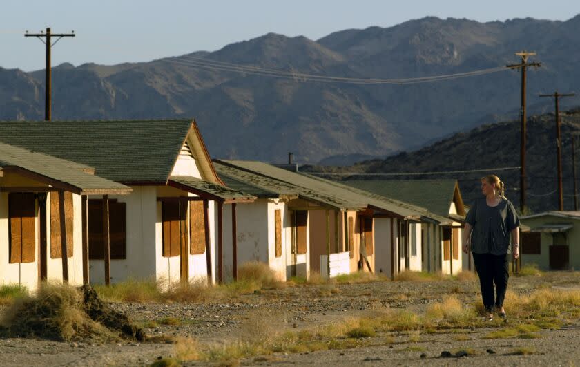 Irfan Khan 909–788–6802 –– – 071411.ME.1001.Eagle.IK ––– Eagle Mountain. Oct. 01, 2003 ––– Connie Ottinger (Cq), who lived for 35 years in Eagle Mountain walk on a street with boarded houses, which was once her neighborhood. Ottinger works for the elementary school which serves comminity's 60 kids. The California Department of Corrections plans to close an adjacent prison by the end of the year. Without the prison, there will be no need for the community of 300 people, most of whom are employees of the facility.