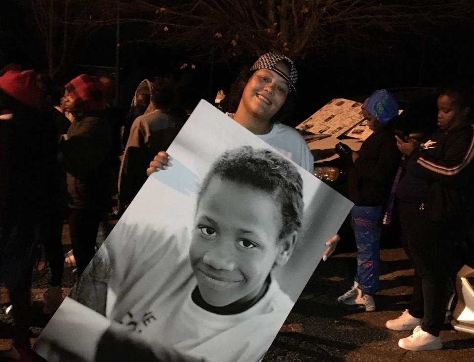 Laquanda Duncan holds a picture of her brother, Teylyn Mcalpin, as a young boy. Duncan and others gathered Nov. 30 in Montford near where Mcalpin was shot to death. He was 17.