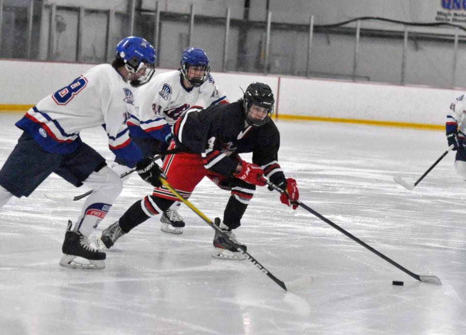 North Quincy's Michael Silverman, right, keeps the puck away from Quincy's Declan Rogers, left, and Joe MacNeil, center, during the Holiday Tournament at the Quincy Youth Arena, Tuesday, Dec. 27, 2022.