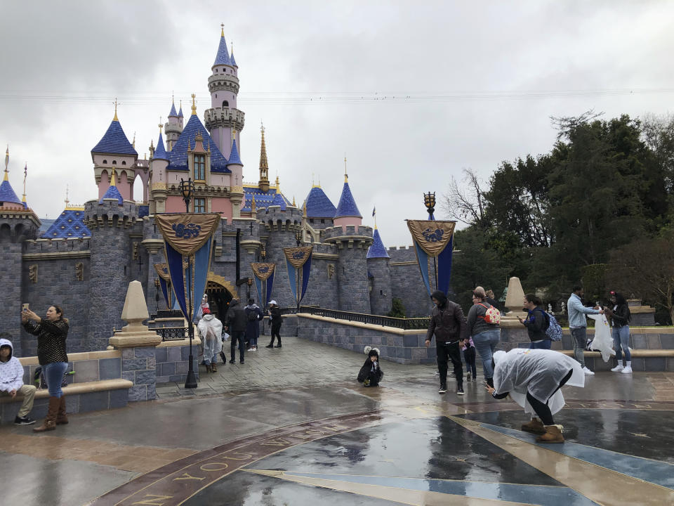 Visitors take photos at Disneyland in Anaheim, Calif., Friday, March 13, 2020. Disneyland is closing its doors for the rest of the month, shuttering one of California's best-known attractions as the state hurries to stop the spread of the coronavirus. (AP Photo/Amy Taxin)