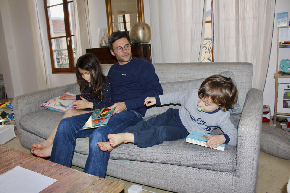 In this photo taken Thursday April 30, 2020 Kimkhi Nguyen plays on a sofa with his children Mila, 7, and Andre, 3, in Paris. As France prepares to start letting public life resume after eight weeks, many parents are deeply torn over a question without a clear or conclusive answer: Should I send my child back to school? The French government is easing some of the closure and home-confinement orders it imposed March 17 to curb coronavirus infections, with businesses permitted to reopen, residents cleared to return to workplaces and schools welcoming some students again starting Monday. (AP Photo/Oleg Cetinic)