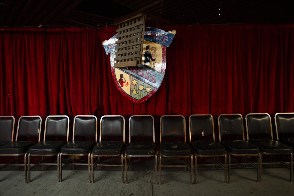 Chairs are lined up under the coat of arms of the Salon Los Angeles during an event to raise money and keep open the iconic dance hall known as “The Cathedral of Mambo” amid the new coronavirus pandemic in Mexico City, Saturday, Sept. 5, 2020. Millionaires, writers, ambassadors, and movie stars danced here; now, shuttered for more than five months due to the pandemic, the owners of the fabled hall say they are in debt and may have to close and demolish it. (AP Photo/Fernando Llano)