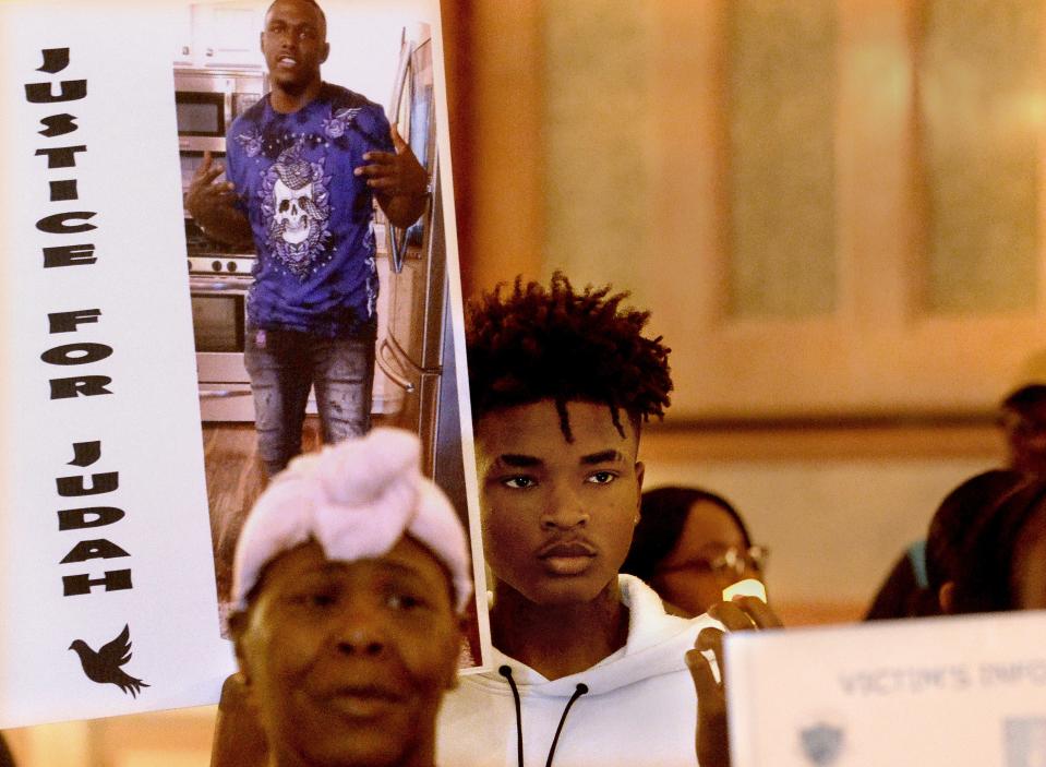 Montez McDaniel of East St. Louis holds up a photo of his cousin who was a crime victim during the candle light portion of Survivors Speak Illinois rally in the state Capitol rotunda Thursday, April 20, 2023.