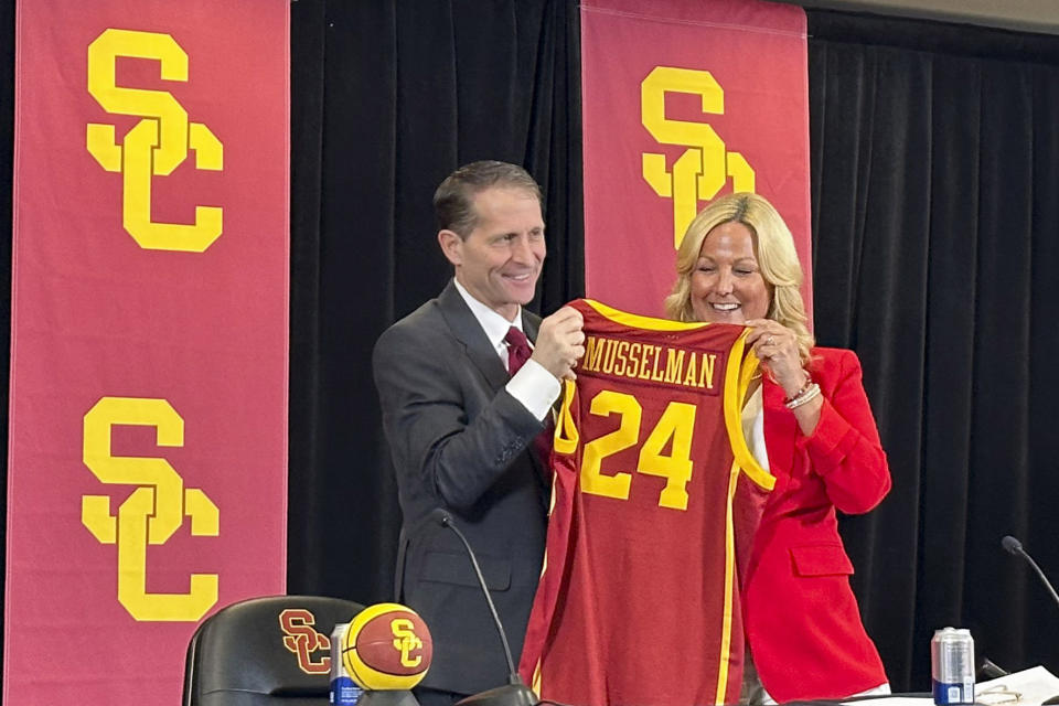 Eric Musselman, left, holds a jersey next to athletic director Jennifer Cohen introduction as the new head coach of Southern California's NCAA college basketball team, Friday, April 5, 2024, in Los Angeles. (AP Photo/Beth Harris)