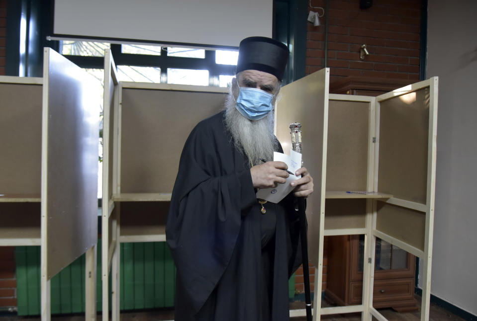 Serbian Orthodox bishop Amfilohije wearing a mask against the spread of the coronavirus prepares to vote in parliamentary elections at a polling station in Cetinje, south of Podgorica, Montenegro, Sunday, Aug. 30, 2020. Voters in Montenegro on Sunday cast ballots in a tense election that is pitting the long-ruling pro-Western party against the opposition seeking closer ties with Serbia and Russia. (AP Photo/Risto Bozovic)