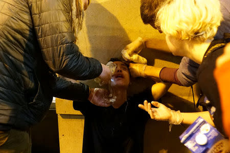 A demonstrator is treated for dispersant exposure during a protest against the election of Republican Donald Trump as President of the United States in Portland, Oregon, U.S. November 12, 2016. REUTERS/Cole Howard