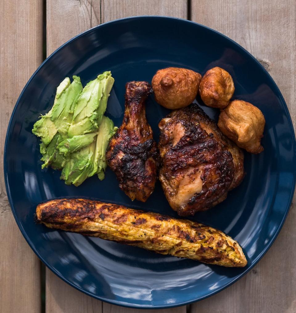 A plate of Nigerian puff puff, boiled corn, and chicken.