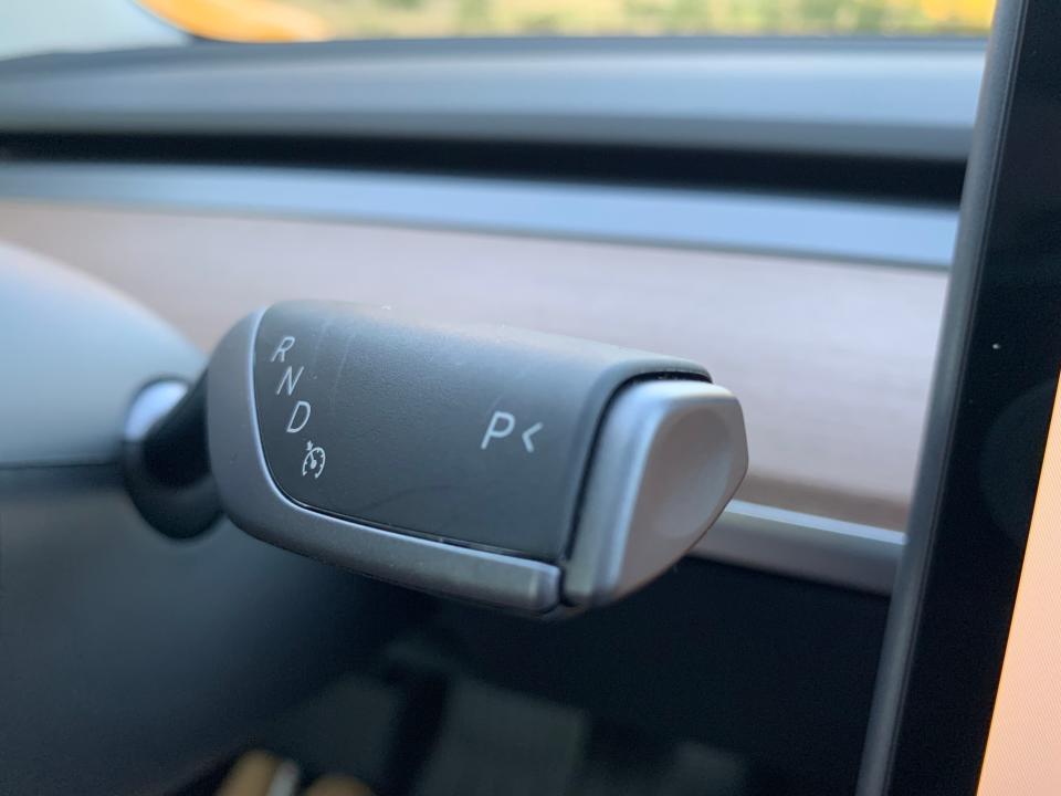 An up-close photo of Tesla's gear shift, which is located behind the steering wheel.