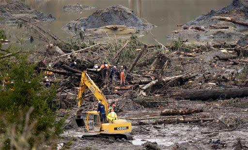 Workers search by hand and with heavy equipment Sunday, March 30, 2014, near Darrington, Wash., for victims of the Saturday, March 22 mudslide that hit the nearby community of Oso, Wash. (AP Photo/Ted S. Warren)