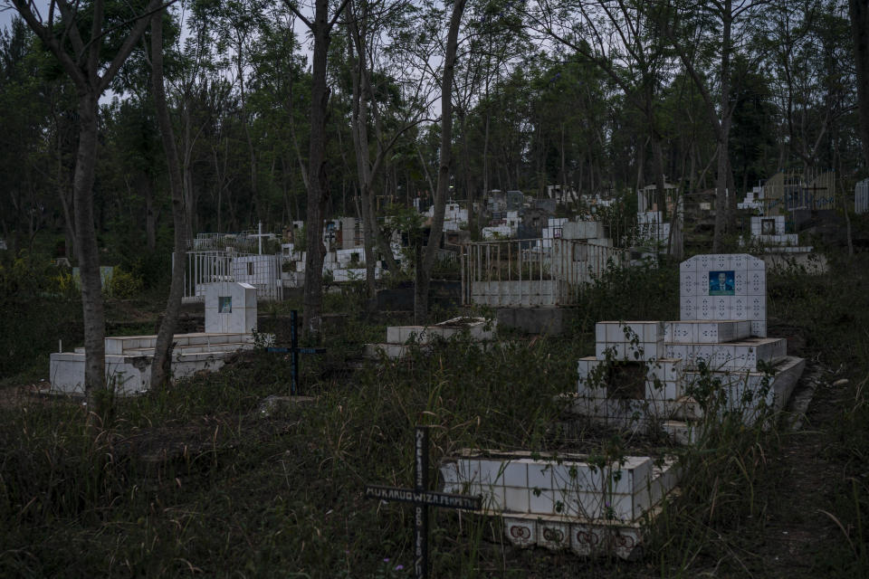 In this Sept. 9, 2019 photo, crosses and tombstones stand under trees in a cemetery in Kigali, Rwanda. A 2012 census put the number of annual deaths in Rwanda at about 80,000, but experts say the true count is not really known, partly because just a fraction of deaths occur in hospitals and are medically certified. (AP Photo/Felipe Dana)