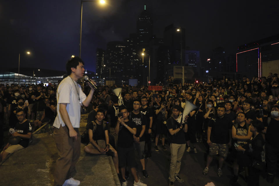 Pro-democracy lawmaker Roy Kwong speaks to protesters who have gathered into the night against an unpopular extradition bill in Hong Kong on Sunday, June 16, 2019. Hong Kong citizens marched for hours Sunday in a massive protest that drew a late-in-the-day apology from the city's top leader for her handling of legislation that has stoked fears of expanding control from Beijing in this former British colony. (AP Photo/Kin Cheung)