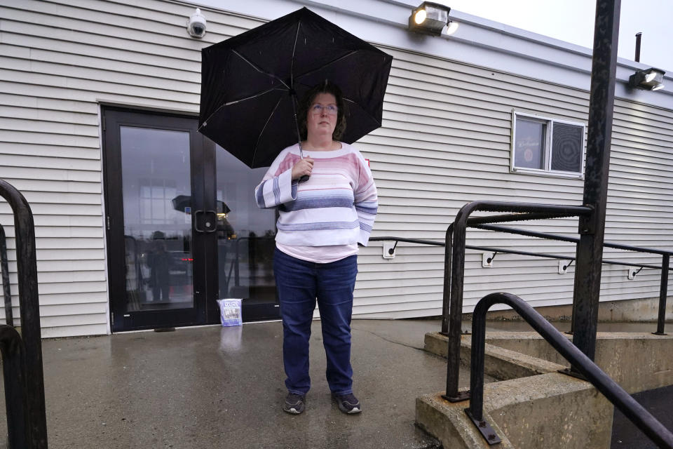 Kathy Lebel, the owner of Schemengees Bar & Grille, which is currently closed due to the mass shootings, stands for a portrait on Wednesday, Dec. 27, 2023, in Lewiston, Maine. Immediately after Maine's deadliest mass shooting, the owners of the bowling alley and the bar in Lewiston where the gunman killed a total of 18 people were certain their doors were closed for good. But as time passed following the Oct. 25 shooting, they came to the same conclusion: They had to reopen. (AP Photo/Charles Krupa)