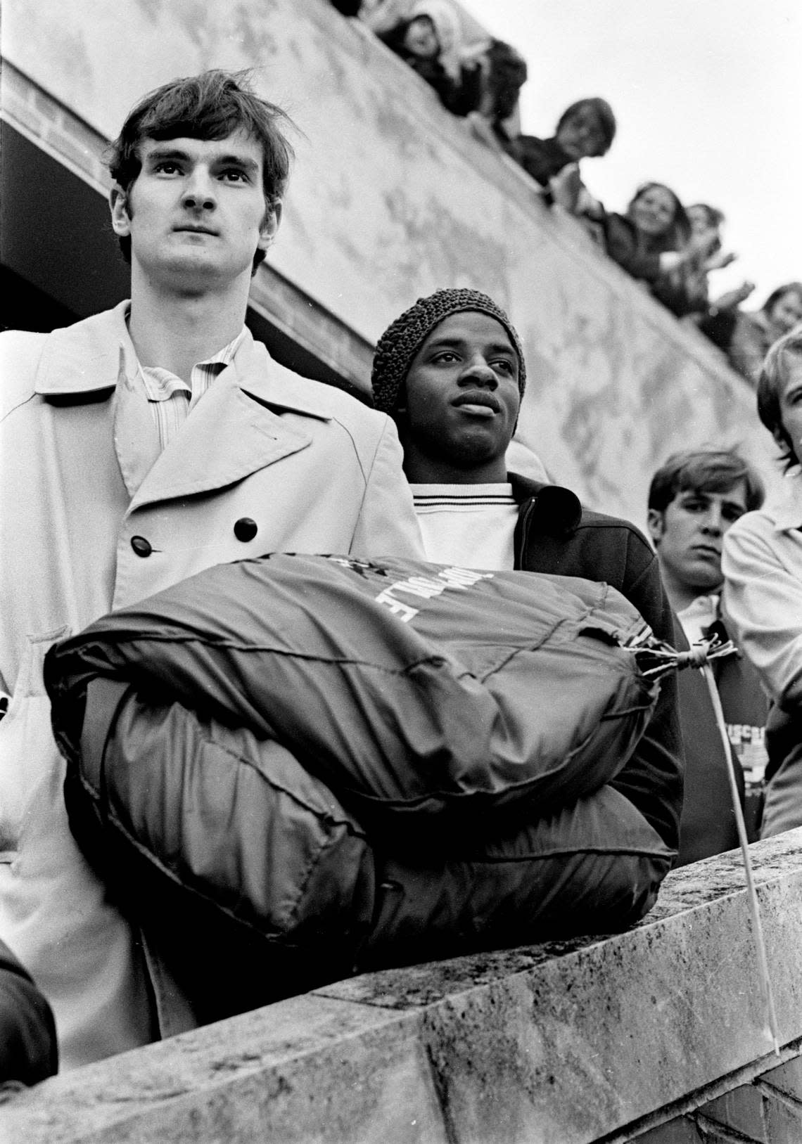 NC State’s Tommy Burleson (left) and David Thompson leave Reynolds Coliseum to board buses to take the Wolfpack to the 1974 Final Four.