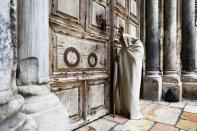 A man stands in front of the closed doors of the Church of the Holy Sepulchre on Good Friday amid the coronavirus disease (COVID-19) outbreak, in Jerusalem's Old City