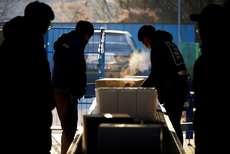 Parcel delivery workers for CJ Logistics, work at its distribution center in Gwangju