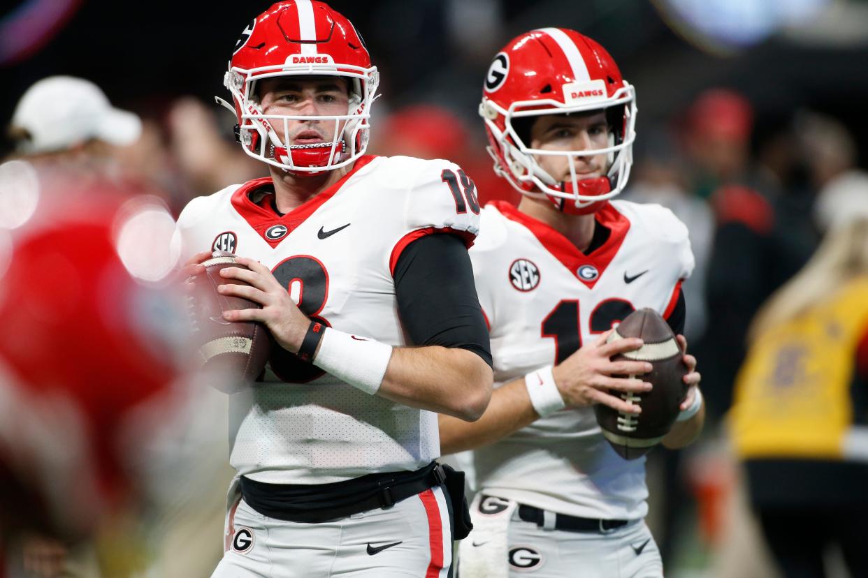 Georgia quarterback JT Daniels (18) and Georgia quarterback Stetson Bennett (13) warm up before the start the Southeastern Conference championship NCAA college football game between Georgia and Alabama in Atlanta, on Saturday, Dec. 4, 2021.