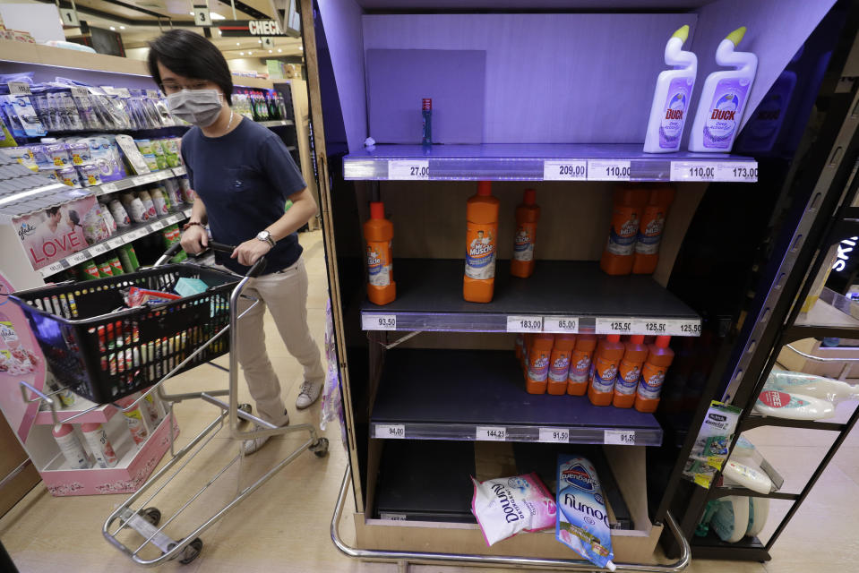 A woman wearing a protective mask walks past shelves which contain disinfectants at a supermarket in Taguig, metropolitan Manila, Philippines on Friday, March 13, 2020. Many people trooped to supermarkets and stocked up on supplies as the Philippine president announced Thursday that domestic travel to and from metropolitan Manila will be suspended for a month and authorized sweeping quarantines in the crowded capital to fight the new coronavirus.(AP Photo/Aaron Favila)