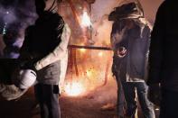 Participants wearing motorcycle helmets get sprayed with firecrackers, during the 'Beehive Firecrackers' festival at the Yanshui district in Tainan