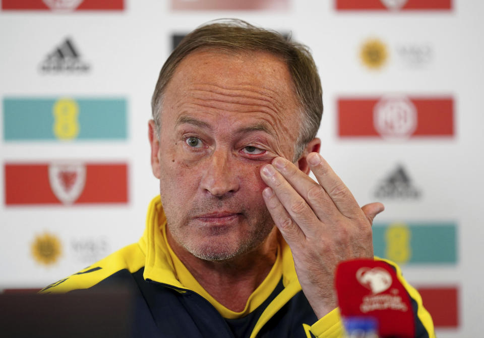 Ukraine manager Oleksandr Petrakov wipes his eye during a press conference at the Cardiff City Stadium, Cardiff, Wales Saturday June 4, 2022, the day before his team play Wales in a World Cup play-off soccer match. (Mike Egerton/PA via AP)