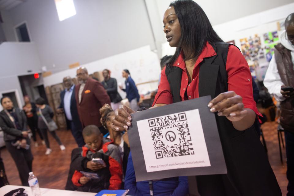 LaRonna Lassiter Saunders, legal representative for the Lowery and Kelley families, holds up a QR code to an online petition asking for the City of Topeka to release body cam footage of the Kelley and Lowery shootings.