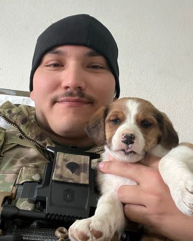 <p>Courtesy of Paws of War</p> A solider with a dog they adopted while overseas