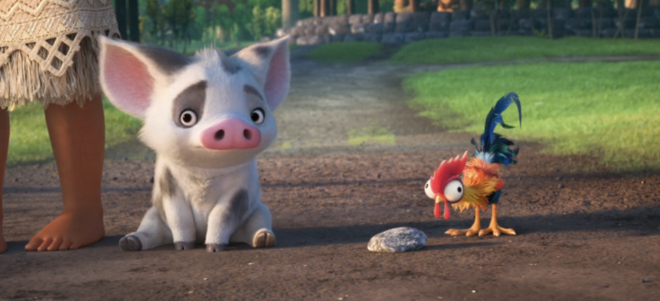 Pua the pig and Heihei the rooster from "Moana" looking curiously at a stone