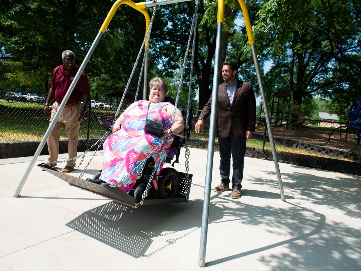 Mayor Scott Conger pushes Amy Dyer during a demonstration of the new wheelchair accessible swing at Malesus Park in Jackson, Tennessee on July 26, 2023. The wheelchair accessible swing is the second the City of Jackson has installed this year.