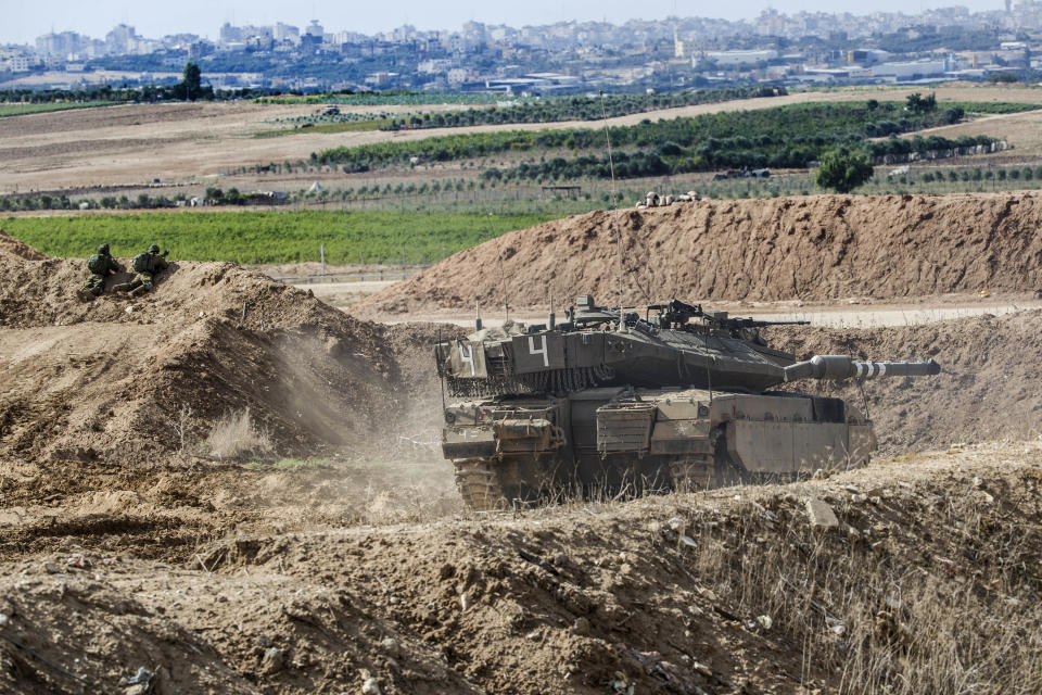 Israeli tank takes a position at the Gaza Strip border, Saturday, Oct. 27, 2018. The Israeli military has struck dozens of targets across the Gaza Strip in response to heavy rocket fire and threatened to expand its air campaign to Syria after accusing Iranian forces in Damascus of orchestrating the rocket attacks. (AP Photo/Tsafrir Abayov)