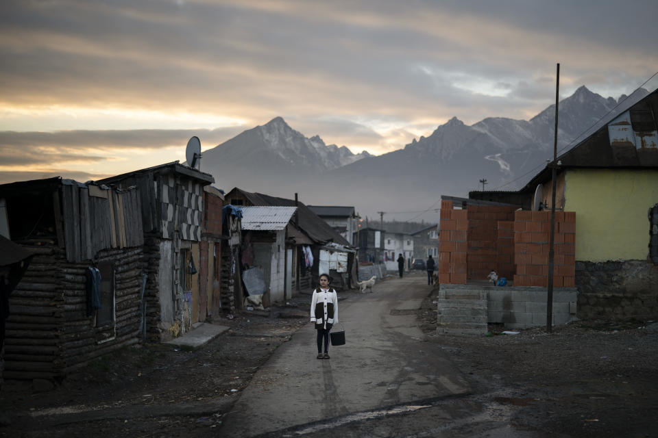 In this Nov. 16, 2018, photo, a Roma girl holds with a bucket to collect water in a village near Kezmarok, Slovakia. An investigation by The Associated Press has found that women and their newborns in Slovakia are routinely, unjustifiably and illegally detained in hospitals across the European Union country. Roma women, vulnerable to racist abuse and physical violence, suffer particularly. They’re also often poor, and mothers who leave hospitals before doctors grant permission forfeit their right to a significant government childbirth allowance of several hundred euros. (AP Photo/Felipe Dana)
