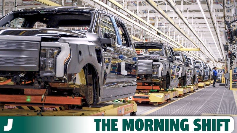 A photo of Ford F-150 Lightning pickups in production at a factory. 
