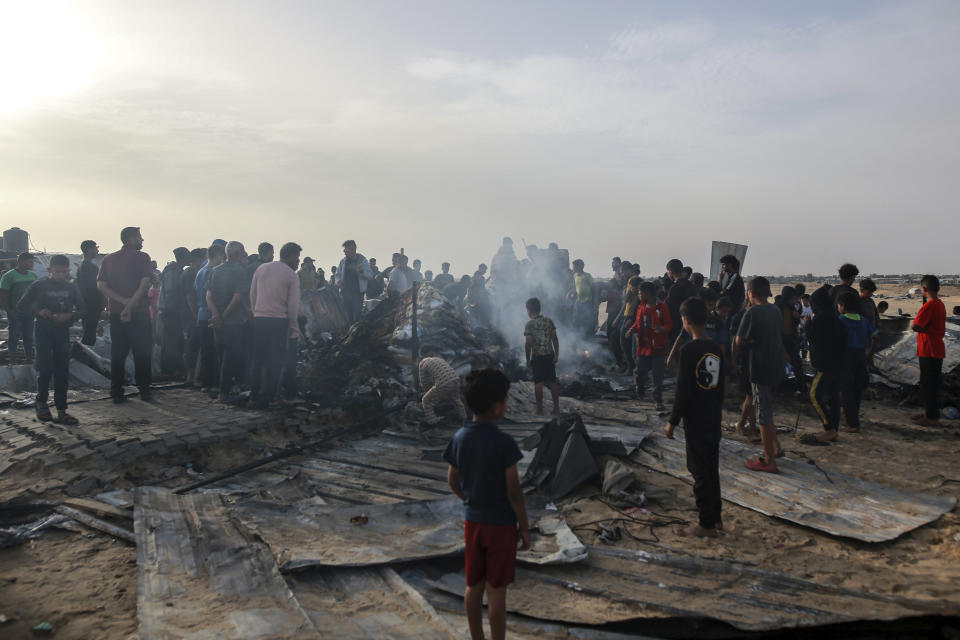 Palestinians look at the destruction after an Israeli strike where displaced people were staying in Rafah, Gaza Strip, Monday, May 27, 2024. Palestinian health workers said Israeli airstrikes killed at least 35 people in the area. Israel's army confirmed Sunday's strike and said it hit a Hamas installation and killed two senior Hamas militants. (AP Photo/Jehad Alshrafi)