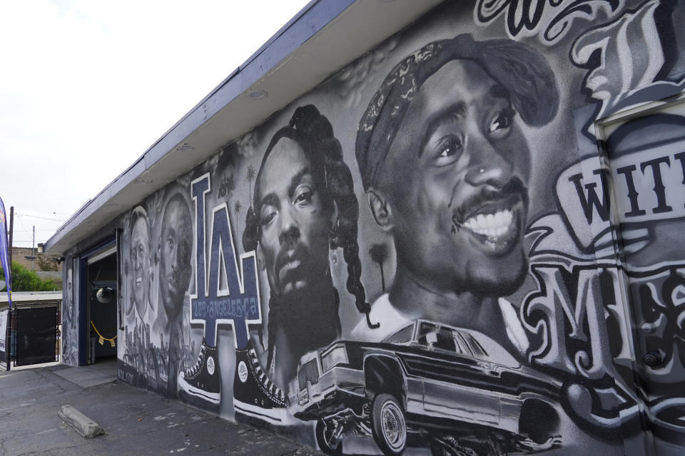 A portion of a mural by artist sloe_motions depicting Oscar De La Hoya, Vin Scully, Kobe Bryant, Snoop Dogg, and Tupac Shakur is seen on the side of Speedy Auto Tint on Friday, Sept. 29, 2023, in Bellflower, Calif. (AP Photo/Chris Pizzello)