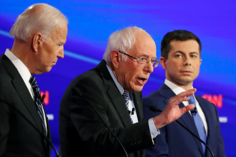 FILE PHOTO: Democratic 2020 U.S. presidential candidates former Vice President Joe Biden listens to Senator Bernie Sanders as former South Bend Mayor Pete Buttigieg looks on in the seventh Democratic 2020 presidential debate at Drake University in Des Moin