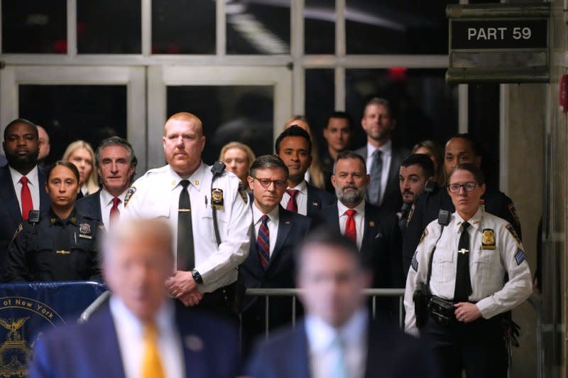 House Speaker Mike Johnson (C), R-LA, and businessman Vivek Ramaswamy listen as former President Donald Trump (CL) talks with reporters at a Manhattan Criminal Court in New York on Tuesday. The speaker spoke to reporters in the morning saying how he believes Trump is "innocent of all charges." Pool photo by Curtis Means/UPI