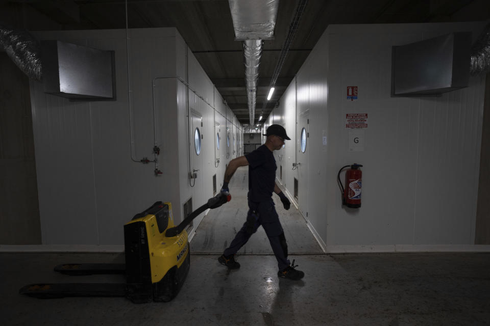 A worker walks past new vertical farm rooms constructed to replace the first egg-laying and larval growth rooms for increased production at the Innovafeed factory in Nesle, France, on Tuesday, June 13, 2023. The company chose the black soldier fly for three main reasons: It doesn’t get sick, eats almost anything and has a short lifecycle that allows it to be bred and harvested quickly. (AP Photo/Aurelien Morissard)