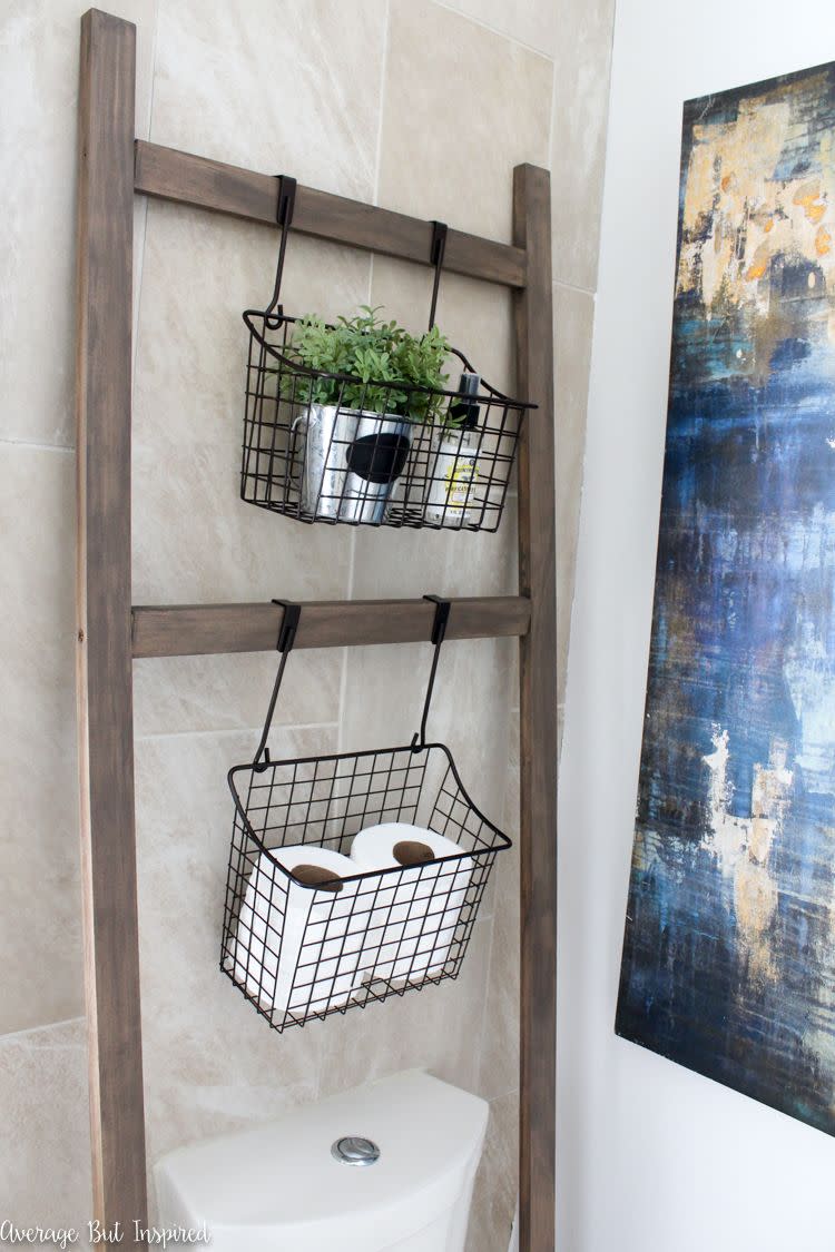 bathoom shelf ideas, a ladder in the bathroom with baskets full of toilet paper