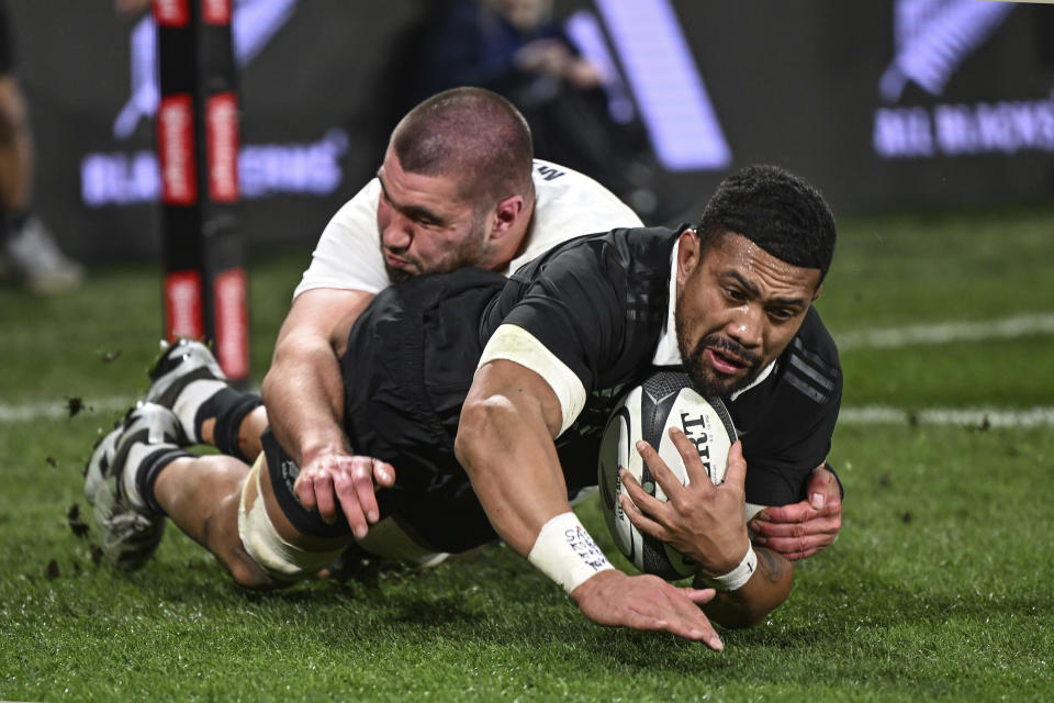 New Zealand's Ardie Savea, right, scores a try against England during their rugby union test match in Dunedin, New Zealand, Saturday July 6, 2024. (Steve McArthur/Photosport via AP)