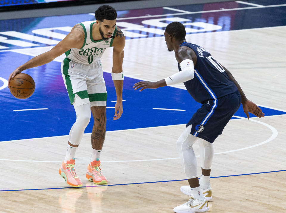 Boston Celtics forward Jayson Tatum (0) dribbles the ball as Dallas Mavericks forward Dorian Finney-Smith (10) defends during the first half of an NBA basketball game in Dallas, Tuesday, Feb. 23, 2021. (AP Photo/Sam Hodde)