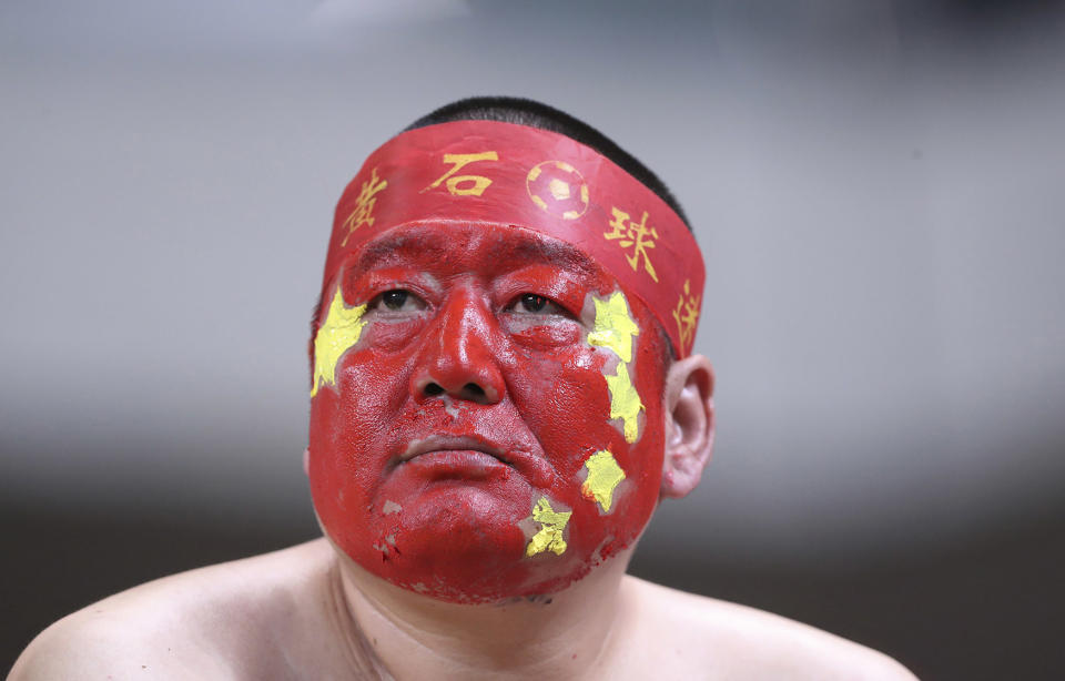 A supporter of the China national soccer team with his face painted in the China’s national color during the soccer match
