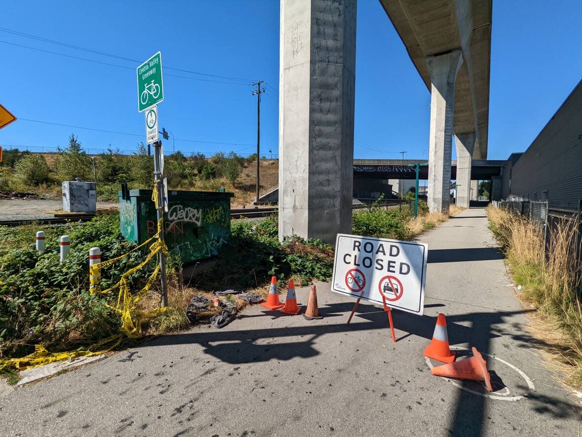 Cyclists are prohibited from entering the section of the Central Valley Greenway bike lane adjacent to where the rooftop of a parking lot collapsed in East Vancouver in July. (@anibyl/Twitter - image credit)