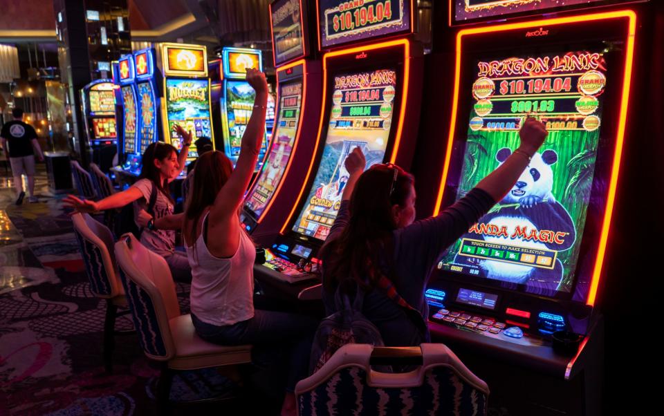 Young women play on the slot machines at Excalibur Hotel & Casino in 2019