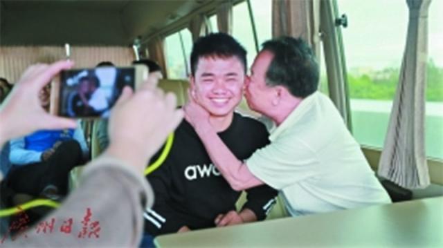 Li Risheng smiles as his biological father kisses him on the cheek when they were reunited. Source: Guangzhou Daily