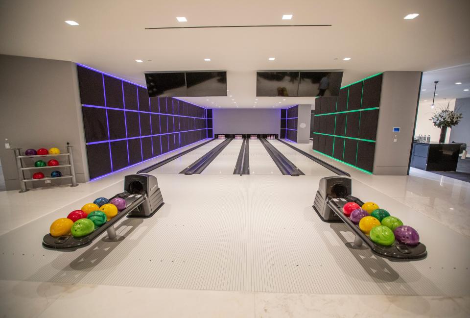 a four-lane bowling alley with purple, green, yellow, and red bowling balls at mansion The One Bel Air