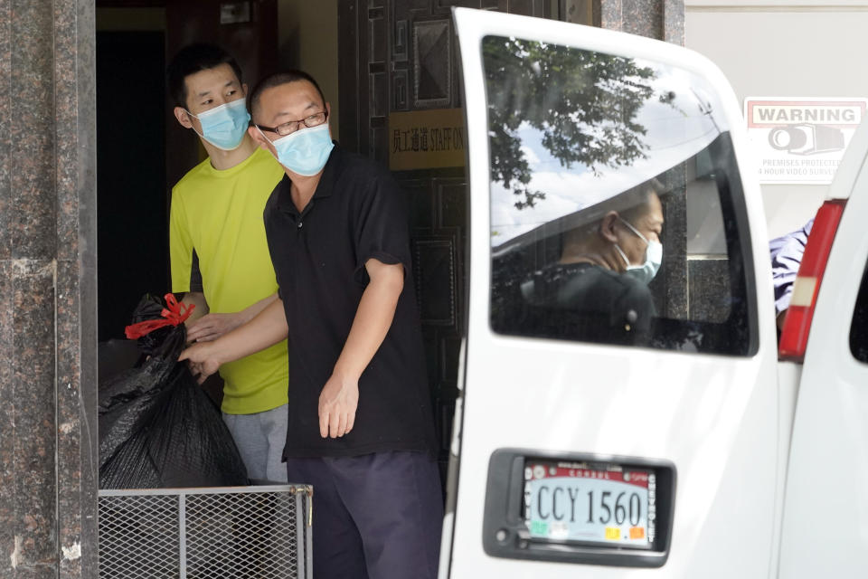 People remove bags from inside the Chinese Consulate to load into a van Thursday, July 23, 2020, in Houston. China says “malicious slander" is behind an order by the U.S. government to close its consulate in Houston, and maintains that its officials have never operated outside ordinary diplomatic norms. (AP Photo/David J. Phillip)