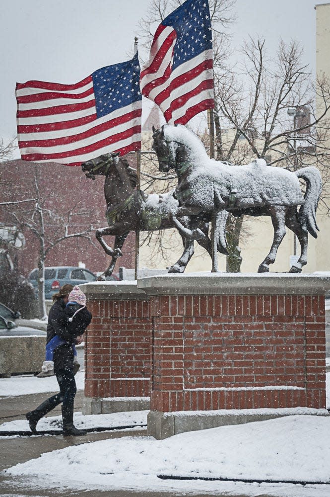 Pedestrians brave the cold and wind during a recent winter in downtown Mansfield.