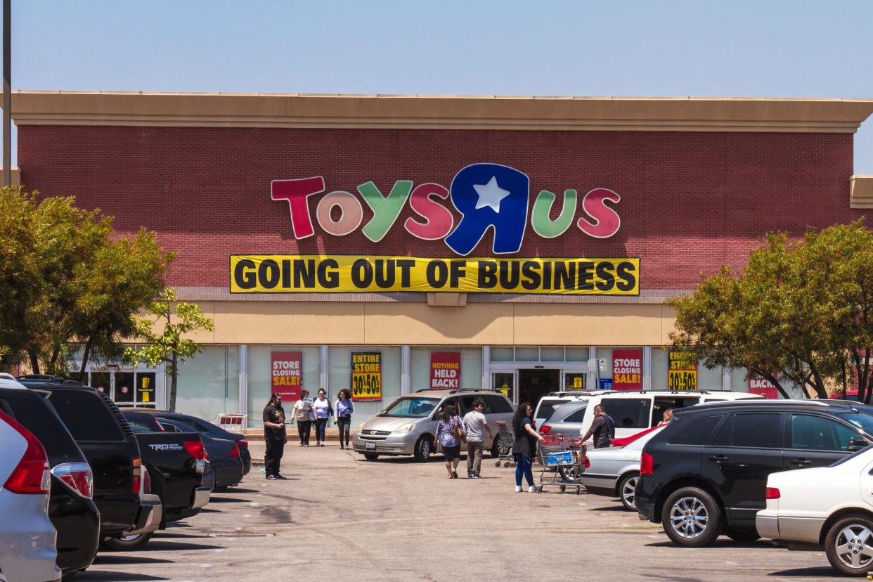 toys r us exterior with going out of business poster, customers walking in front